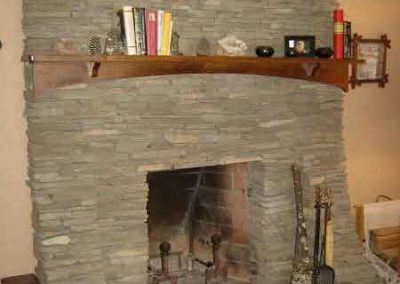 Fireplace Restoration with slat stone and wooden mantle decorations on mantle tools in front of fireplace