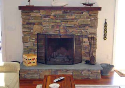 Stacked stone fireplace restoration with swan and boat on mantle-coal scuttle and tools to the rightrmont